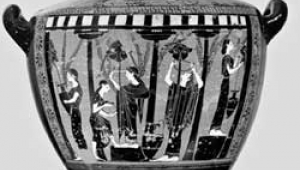 Schwarz-weiß Foto einer antiken Vase: die Vase ist bauchig geformt und hat links und rechts einen schwarzen Griff. Auf der Seite der Vase sind fünf Frauengestalten abgebildet, die in einer Säulenhalle stehen. Einige von ihnen halten Tonkrüge in der Hand.
