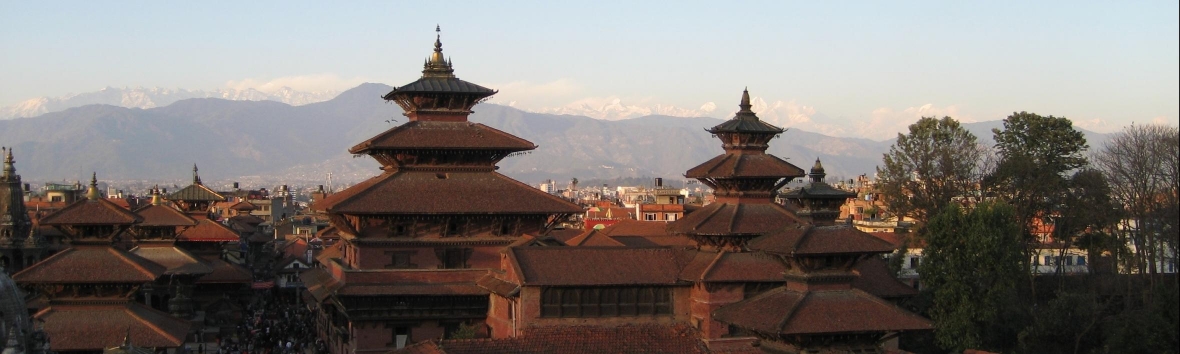 Foto des Palasts der Malla-Könige in Patan, im Hintergrund sind schneebedeckte Berge zu sehen.
