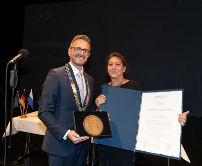 Amirpur Katajun hält Urkunde und OB Medaille bei der Reuchlinpreisvergabe 2022