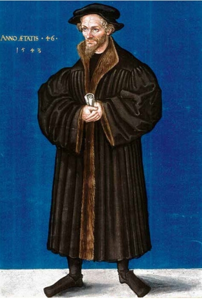 Bildnis von Melanchthon. Er ist vor einem dunkelblauen Hintergrund abgebildet und steht auf hellem Grund. Melanchthon blickt nach links an den Betrachtenden vorbei. Er trägt einen knöchellangen, schweren Mantel mit braunem Pelzbesatz in der Mitte. Dazu trägt er schwarze Schuhe. In der Hand hält er eine Papierrolle. Auf dem Kopf trägt er ein Barett.