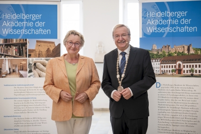 Ministerin Theresia Bauer und Akademiepräsident Bernd Schneidmüller posieren vor Roll-Ups bei der Jahresfeier 2022