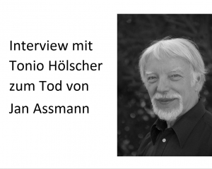 Rechts ein Schwarzweißfoto von Jan Assmann, der den Betrachter im Dreiviertelporträt anlächelt.