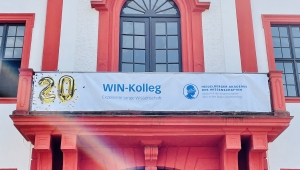 Foto der Frontfassade des Akademiegebäudes mit Schriftzug "20 Jahre WIN-Kolleg" am Balkon