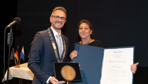 Amirpur Katajun hält Urkunde und OB Medaille bei der Reuchlinpreisvergabe 2022