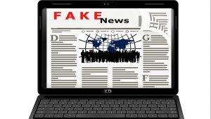 Animation eines aufgeklappten Laptops, auf dem eine Online-Zeitung dargestellt ist, die die Überschrift "FAKE News" trägt.