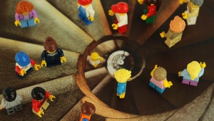 Foto einer Wendeltreppe aus der Vogelperspektive. Auf den einzelnen Stufen sind Legofiguren aufgestellt.