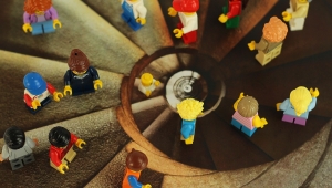 Foto einer Wendeltreppe aus der Vogelperspektive. Auf den einzelnen Stufen sind Legofiguren aufgestellt.
