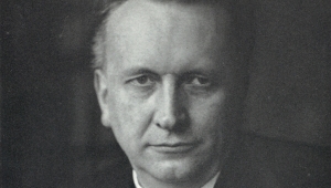Schwarz-weiß Portrait des jüngeren Karl Jaspers in Nahaufnahme. Er trägt ein schwarzes Sakko, dazu eine Weste über einem weißen Hemd und eine dunkle Krawatte. Er schaut mit neutralem Blick in die Kamera.