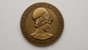 Die Bronzemedaille zeigt den Kopf der Athene als griechischer Göttin der Wissenschaft. Am Rand der Medaille verläuft der Schriftzug Heidelberger Akademie der Wissenschaften 1909.