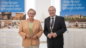 Ministerin Theresia Bauer und Akademiepräsident Bernd Schneidmüller posieren vor Roll-Ups bei der Jahresfeier 2022
