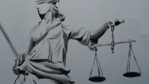 Bleistiftzeichnung der Iustitia. Sie träg ein langes, in Falten liegendes Kleid, in der linken Hand die Waagschale, rechts das Schwert und ein Tuch um ihre Augen gebunden.